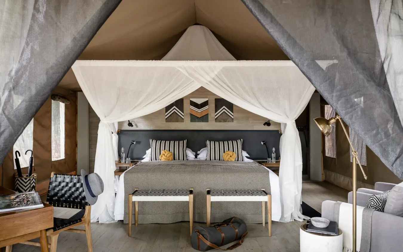 Luxury safari tent bedroom with draped canopy and wooden furnishings, Swala, Tarangire National Park, Tanzania