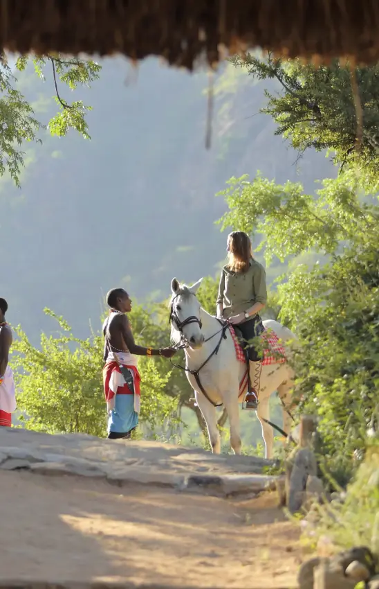 Guests horseback riding on shaded trail with mountain views, Sarara Camp, Northern Kenya, Kenya