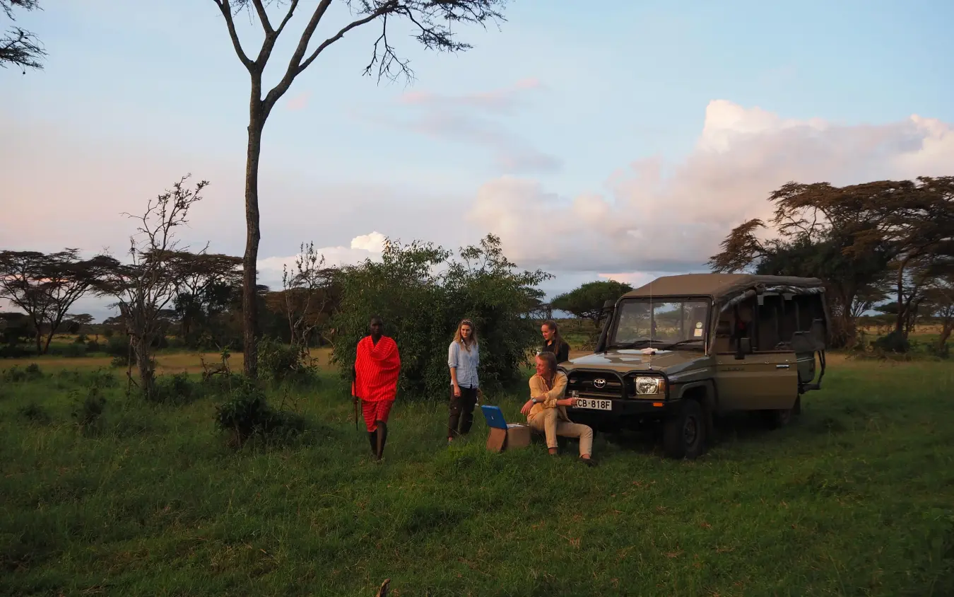 Safari guests meeting with Maasai guide in savanna landscape, Eagle View Camp, Maasai Mara, Kenya