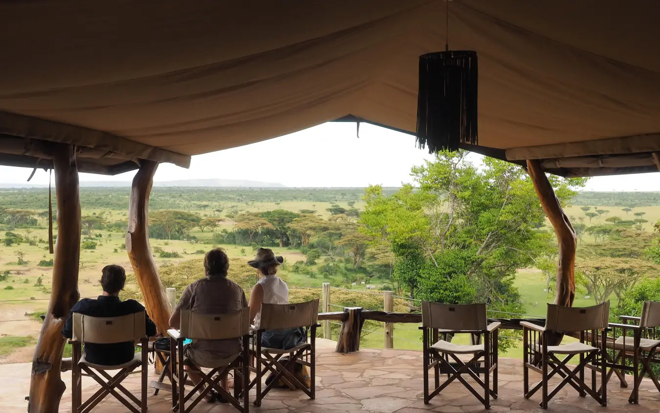 Guests seated on wooden deck overlooking savanna landscape, Eagle View Camp, Maasai Mara, Kenya