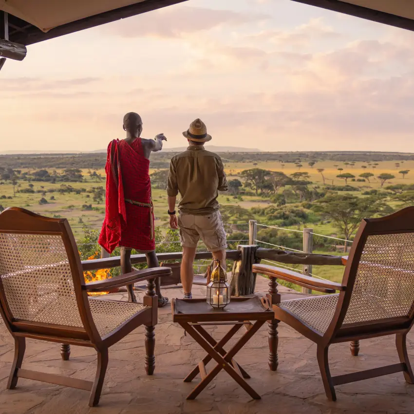 Guests viewing expansive savanna landscape from wooden deck, Eagle View Camp, Maasai Mara, Kenya
