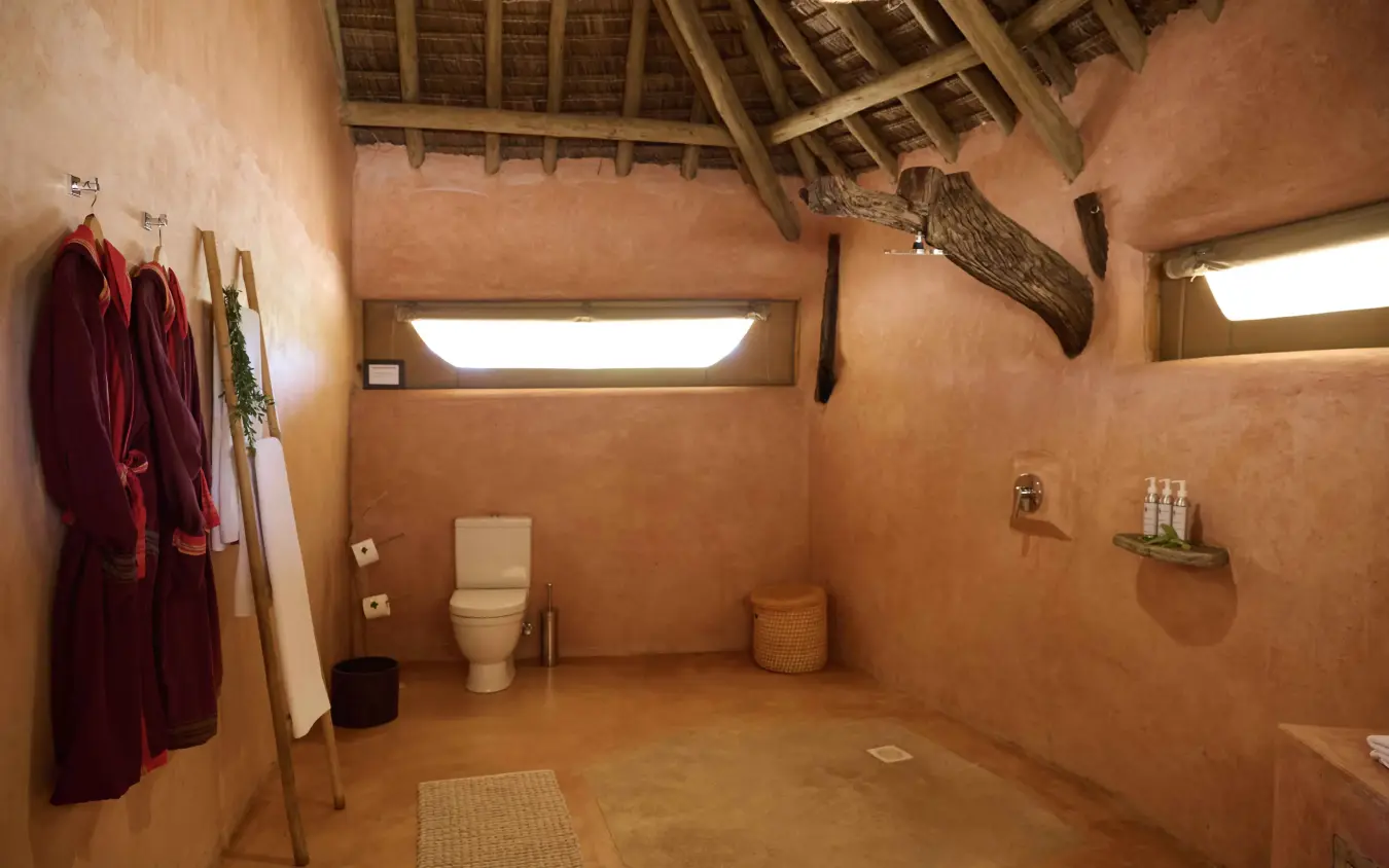 Rustic bathroom with clay walls and thatched ceiling interior, Saruni Rhino, Northern Kenya, Kenya