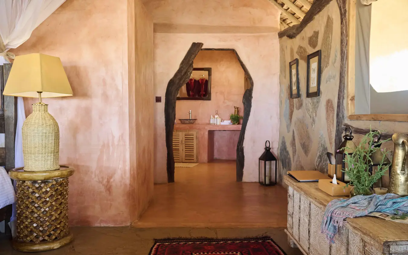 Rustic lodge interior with terracotta walls and wooden beam doorway, Saruni Rhino, Northern Kenya, Kenya