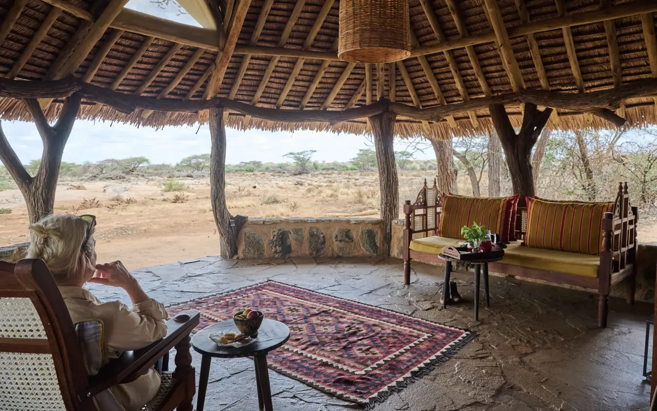 Guest relaxing in open-sided lounge pavilion with savanna views, Saruni Rhino, Northern Kenya, Kenya