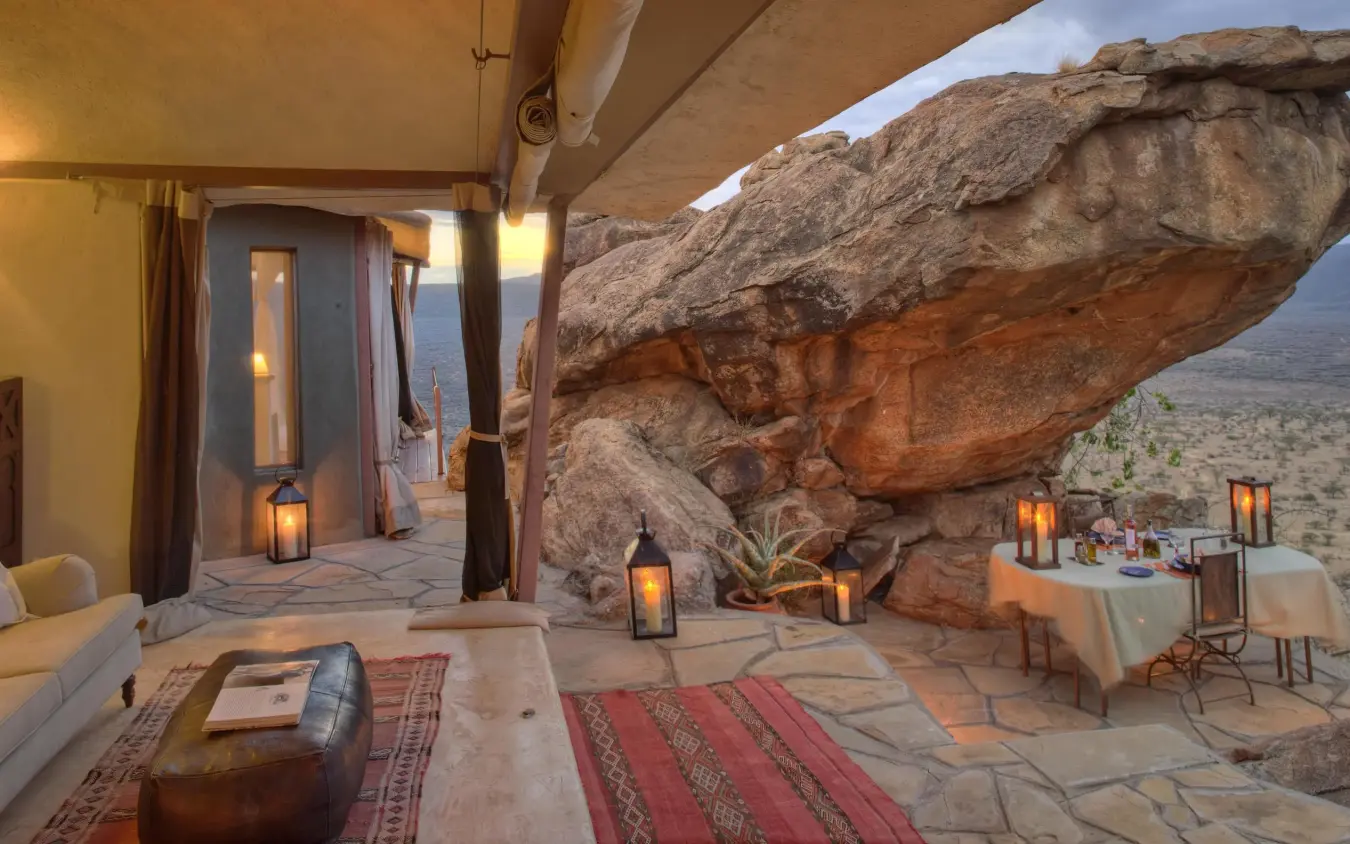 Outdoor lounge area with massive boulder rock formation overlooking savanna landscape, Saruni Samburu, Samburu Reserve, Kenya