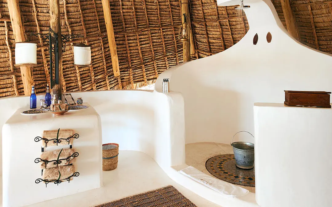 Whitewashed bathroom with thatched roof and traditional furnishings, Sasaab, Samburu Reserve, Kenya