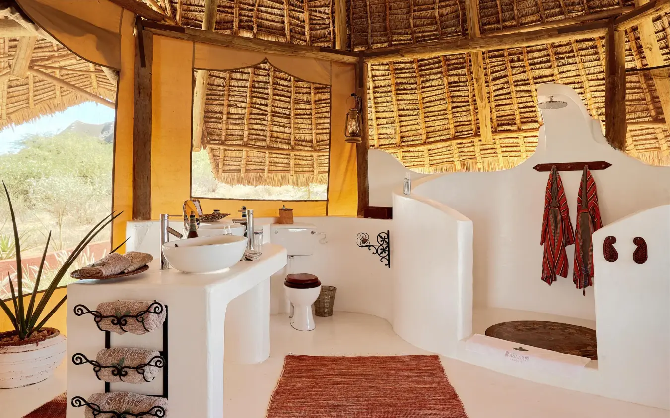 Open-air bathroom with white fixtures and thatched roof, Sasaab, Samburu Reserve, Kenya