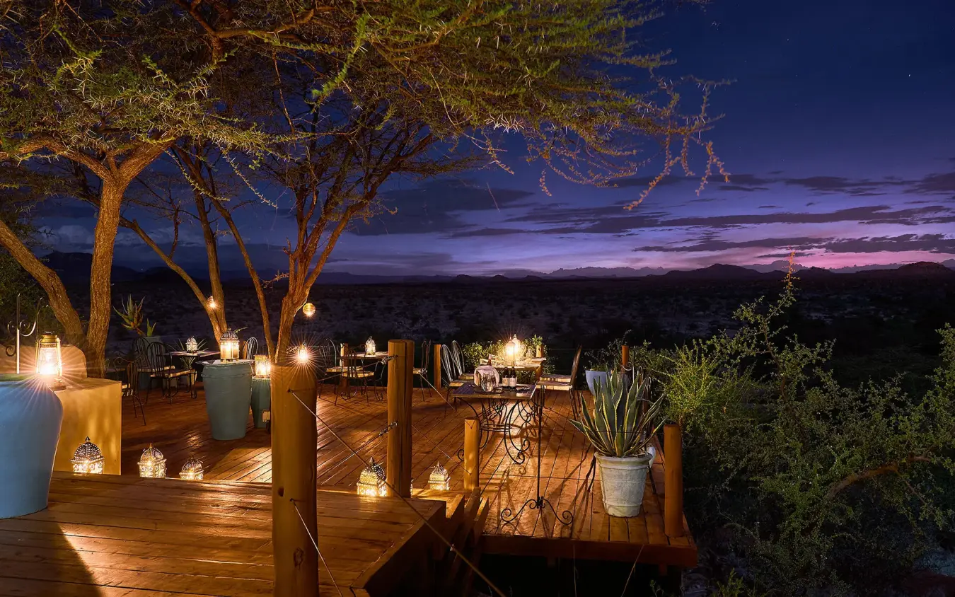 Wooden deck with lanterns overlooking savanna at dusk, Sasaab, Samburu Reserve, Kenya