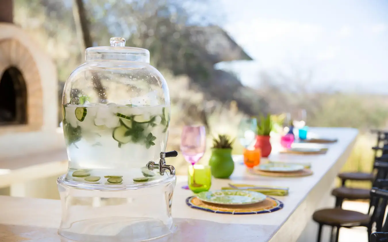 Outdoor dining table with infused water dispenser and place settings, Sasaab, Samburu Reserve, Kenya