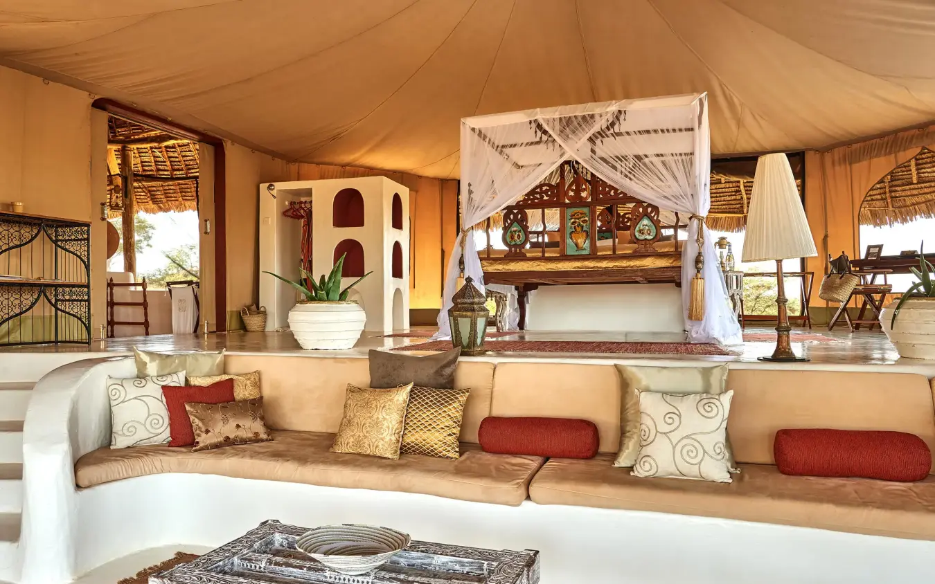 Canvas tent interior with curved seating and canopy bed, Sasaab, Samburu Reserve, Kenya
