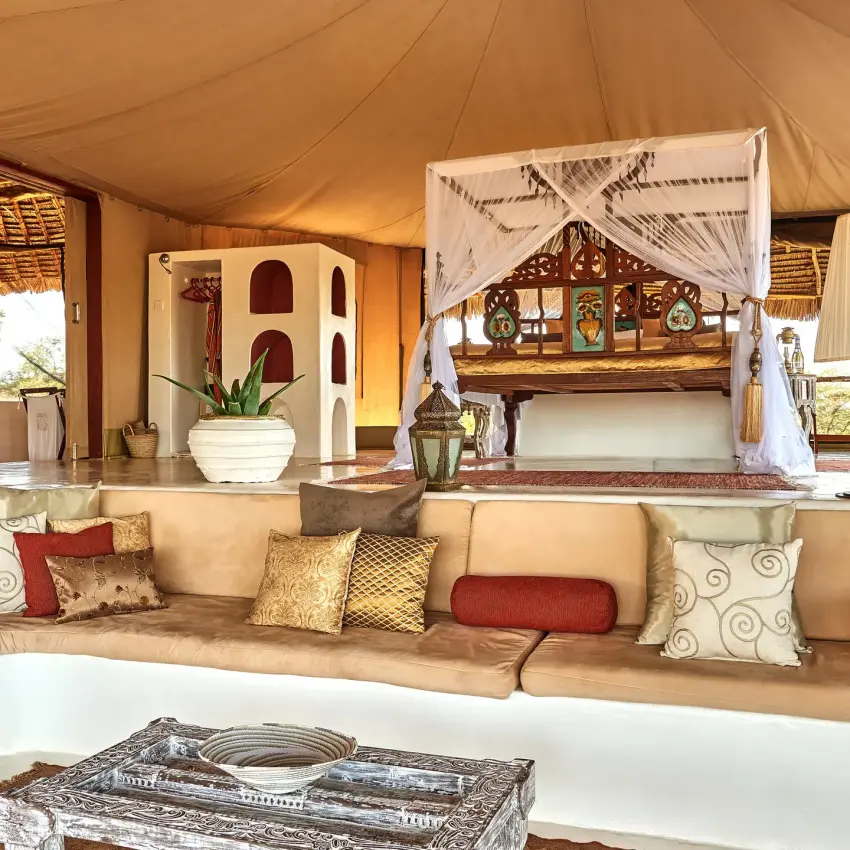 Canvas tent interior with curved seating and canopy bed, Sasaab, Samburu Reserve, Kenya