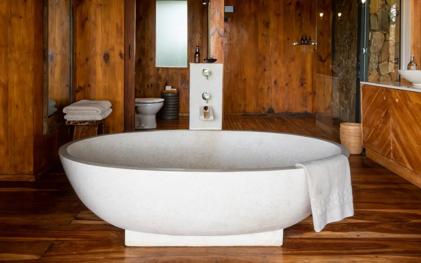 Modern white stone bathtub with wooden interior walls, Sayari Camp, Serengeti National Park, Tanzania