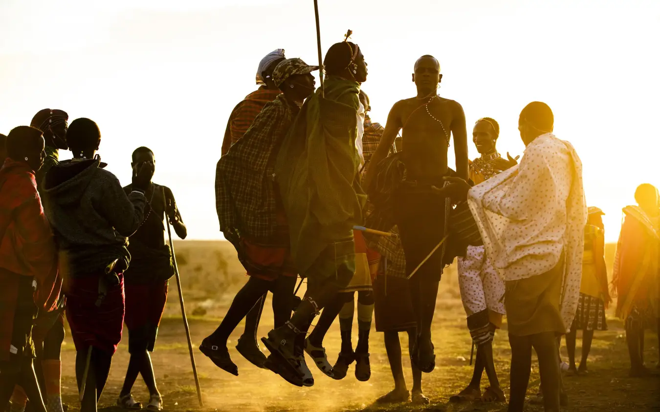 Group of local people jumping together at sunset, Kenya