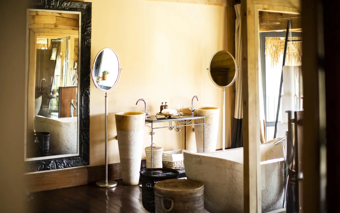 Luxury bathroom with stone pedestal sinks and round mirrors, Segera, Laikipia Highlands, Kenya