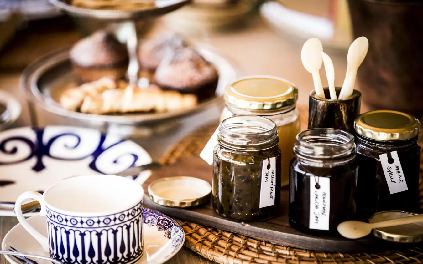Close-up of table setting with tea cup and condiment jars, Segera, Laikipia Highlands, Kenya