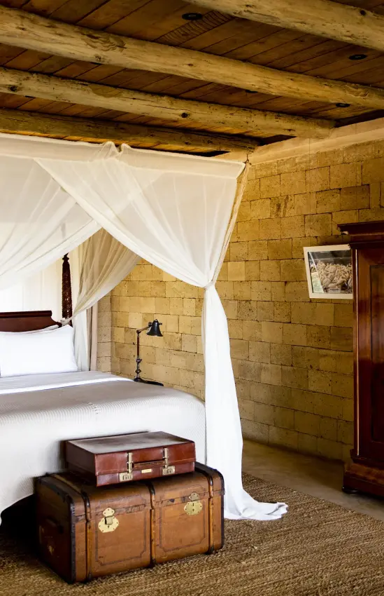 Bedroom with four-poster canopy bed and wooden beams, Segera, Laikipia Highlands, Kenya
