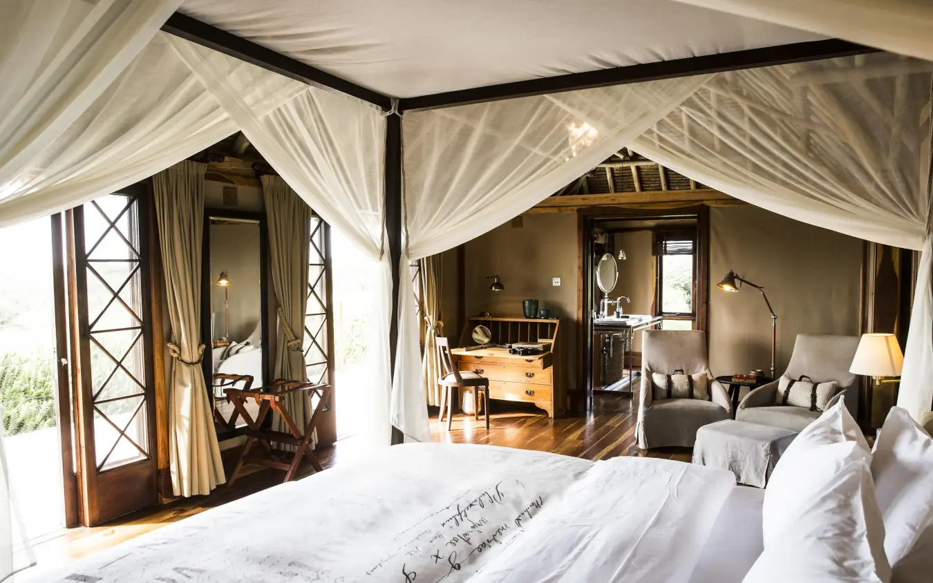 Luxury bedroom with four-poster canopy bed and lounge area, Segera, Laikipia Highlands, Kenya