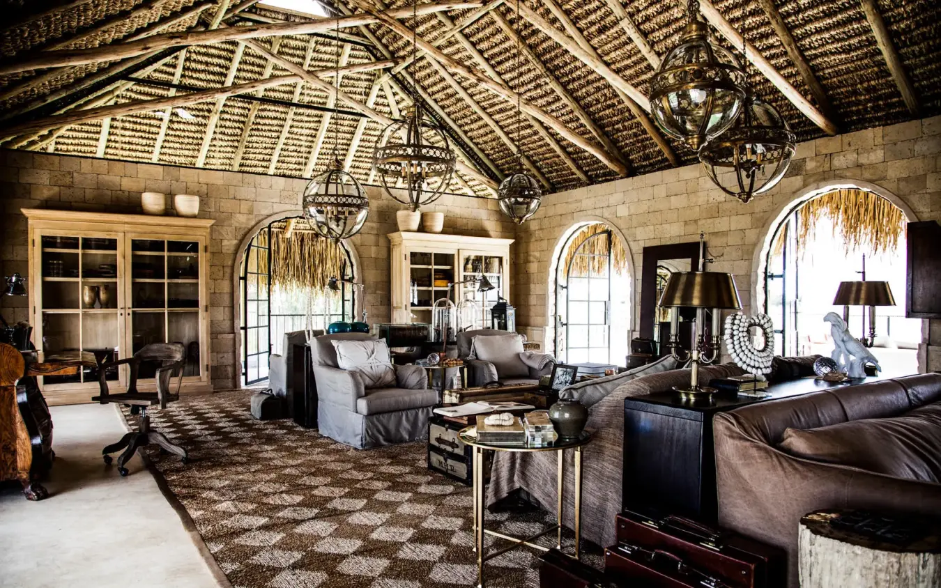 Luxury lounge with stone walls, leather furnishings, and wooden ceiling, Segera, Laikipia Highlands, Kenya