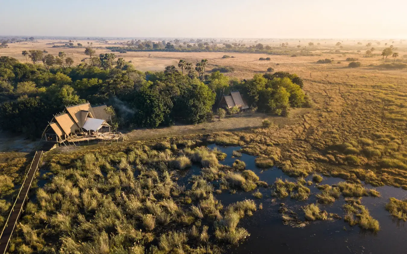 Aerial view of safari lodge beside river and wetlands, Selinda Camp, Selinda Reserve, Botswana