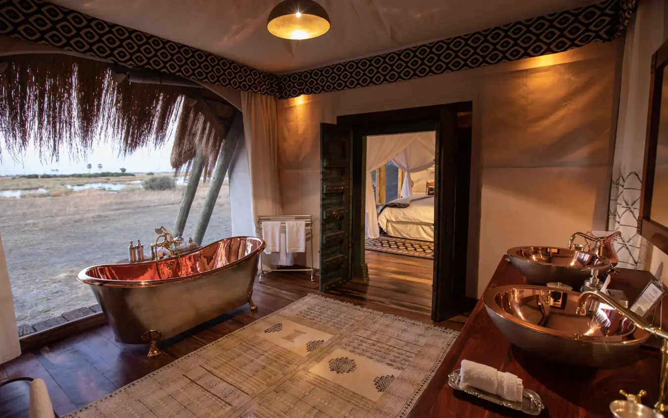 Luxury copper bathtub with river view through window, Selinda Camp, Selinda Reserve, Botswana