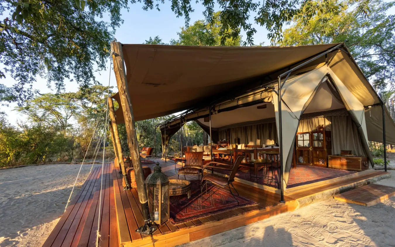 Safari tent with wooden deck and canvas awning at sunset, Selinda Explorers Camp, Selinda Reserve, Botswana