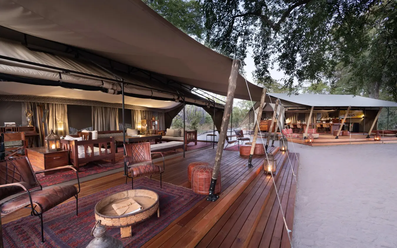 Safari camp lounge area with canvas tents and wooden deck, Selinda Explorers Camp, Selinda Reserve, Botswana