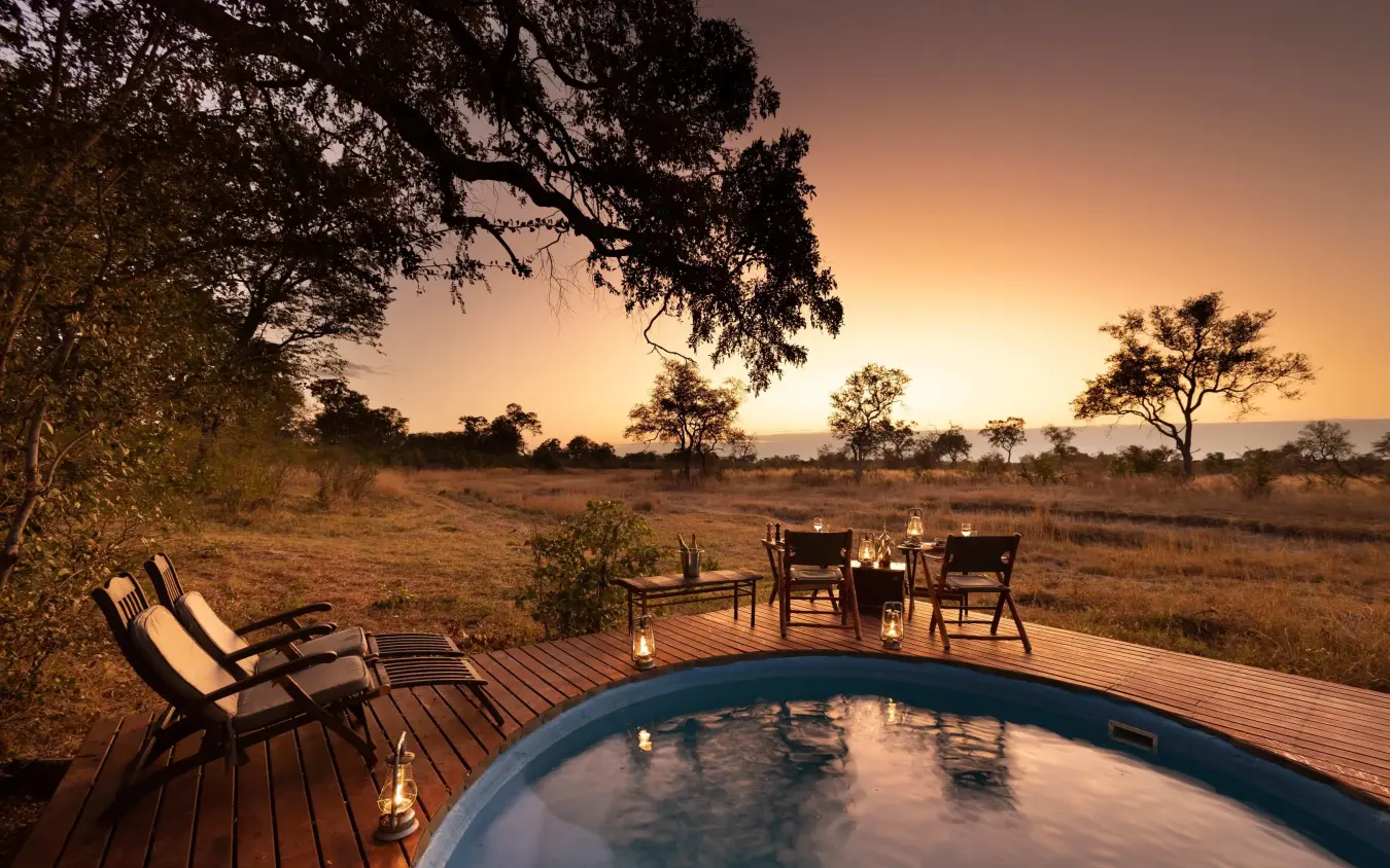 Circular pool on wooden deck overlooking African savanna at sunset, Selinda Explorers Camp, Selinda Reserve, Botswana