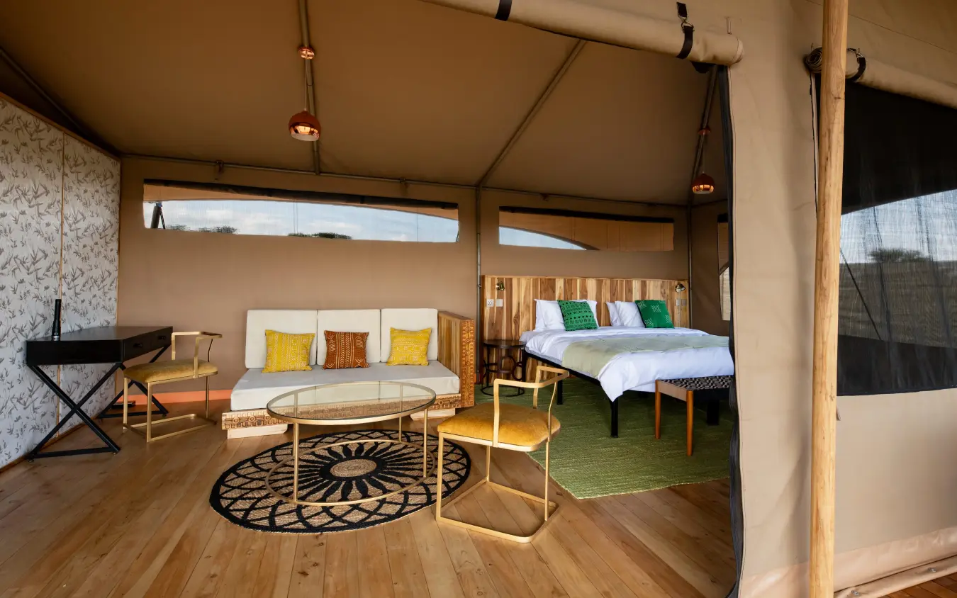 Luxury safari tent interior with bed and lounge seating, Serengeti Plains Camp, Serengeti National Park, Tanzania