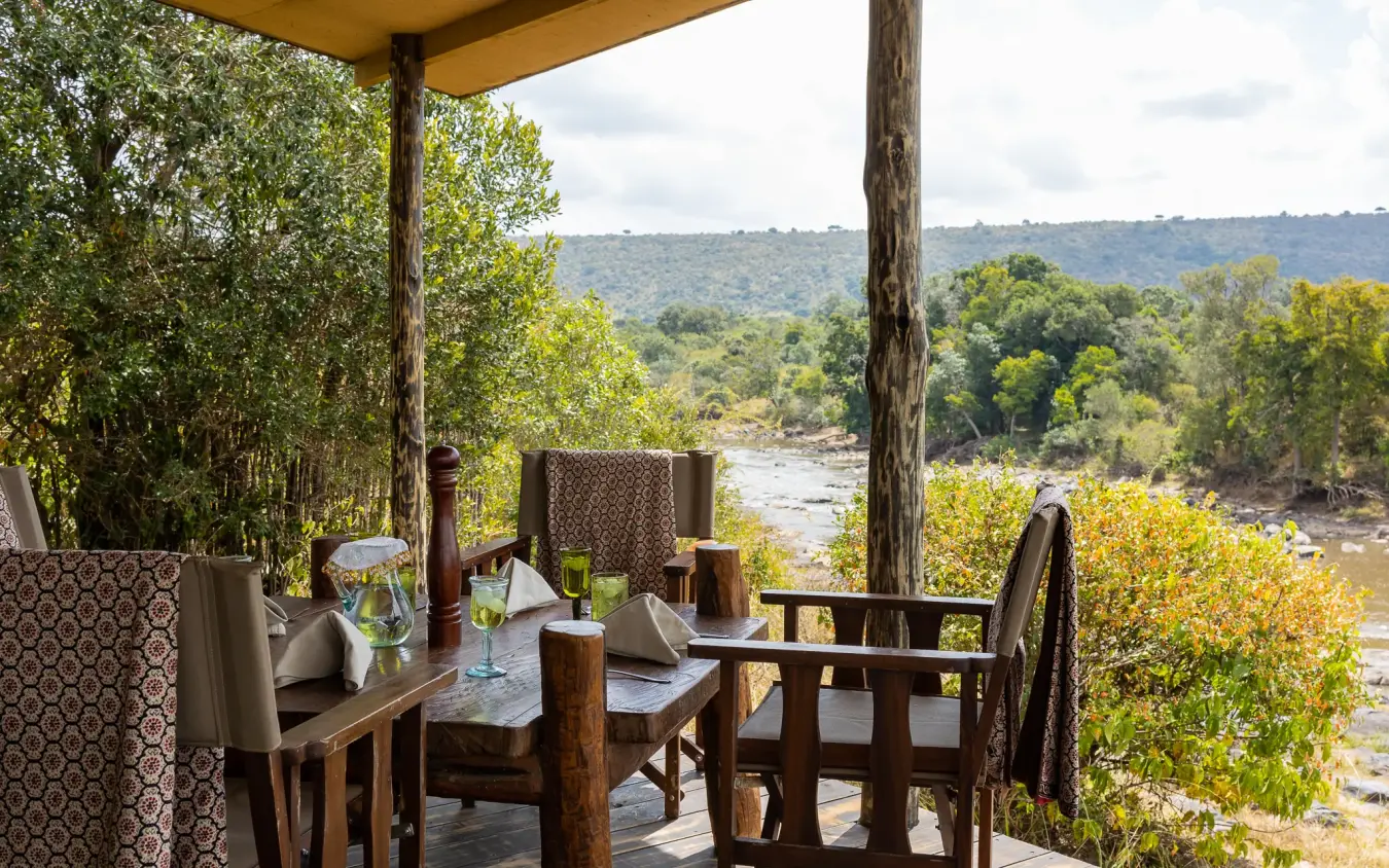Riverside dining deck overlooking river and woodland landscape, Serian Kimya Kimya, Maasai Mara, Kenya