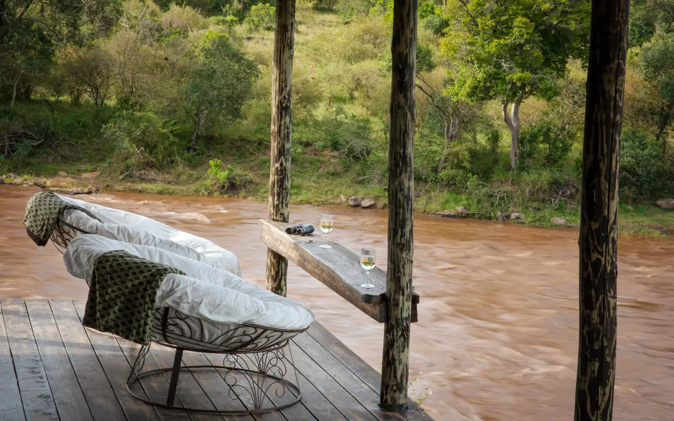 Wooden deck overlooking muddy river with tall trees, Serian Kimya Kimya, Maasai Mara, Kenya