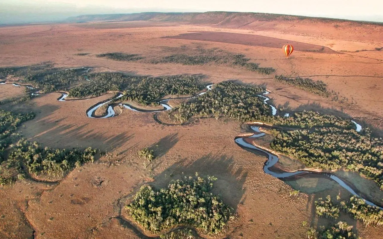 Winding river through savanna woodland with hot air balloon, Serian “The Original”, Maasai Mara, Kenya