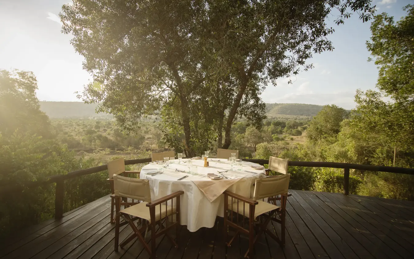 Dining table set on wooden deck overlooking savanna landscape, Serian “The Original”, Maasai Mara, Kenya