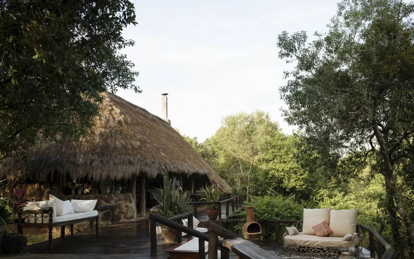 Thatched-roof lodge pavilion with wooden deck and seating areas, Serian “The Original”, Maasai Mara, Kenya