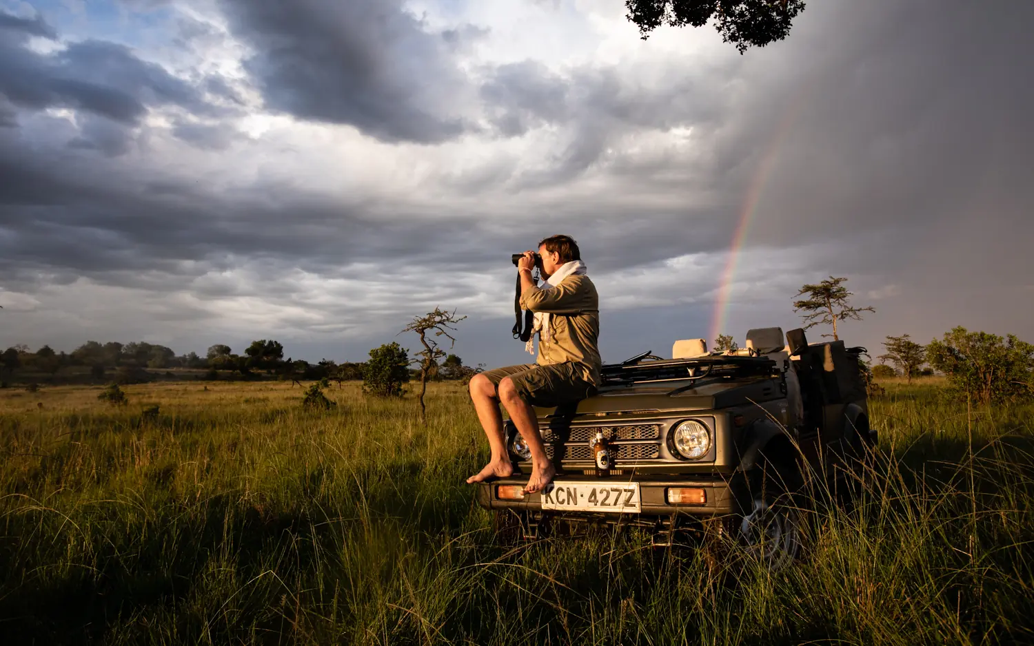 Safari guide photographing wildlife from open vehicle, Serian “The Original”, Maasai Mara, Kenya