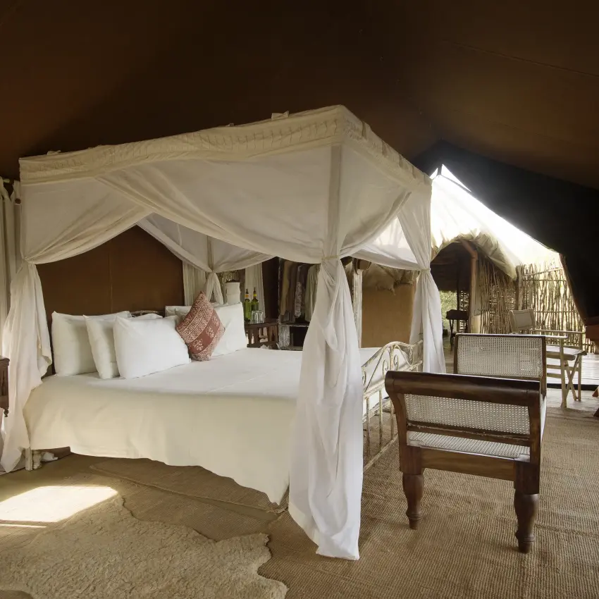 Luxurious bedroom with four-poster canopy bed and draped curtains, Serian “The Original”, Maasai Mara, Kenya