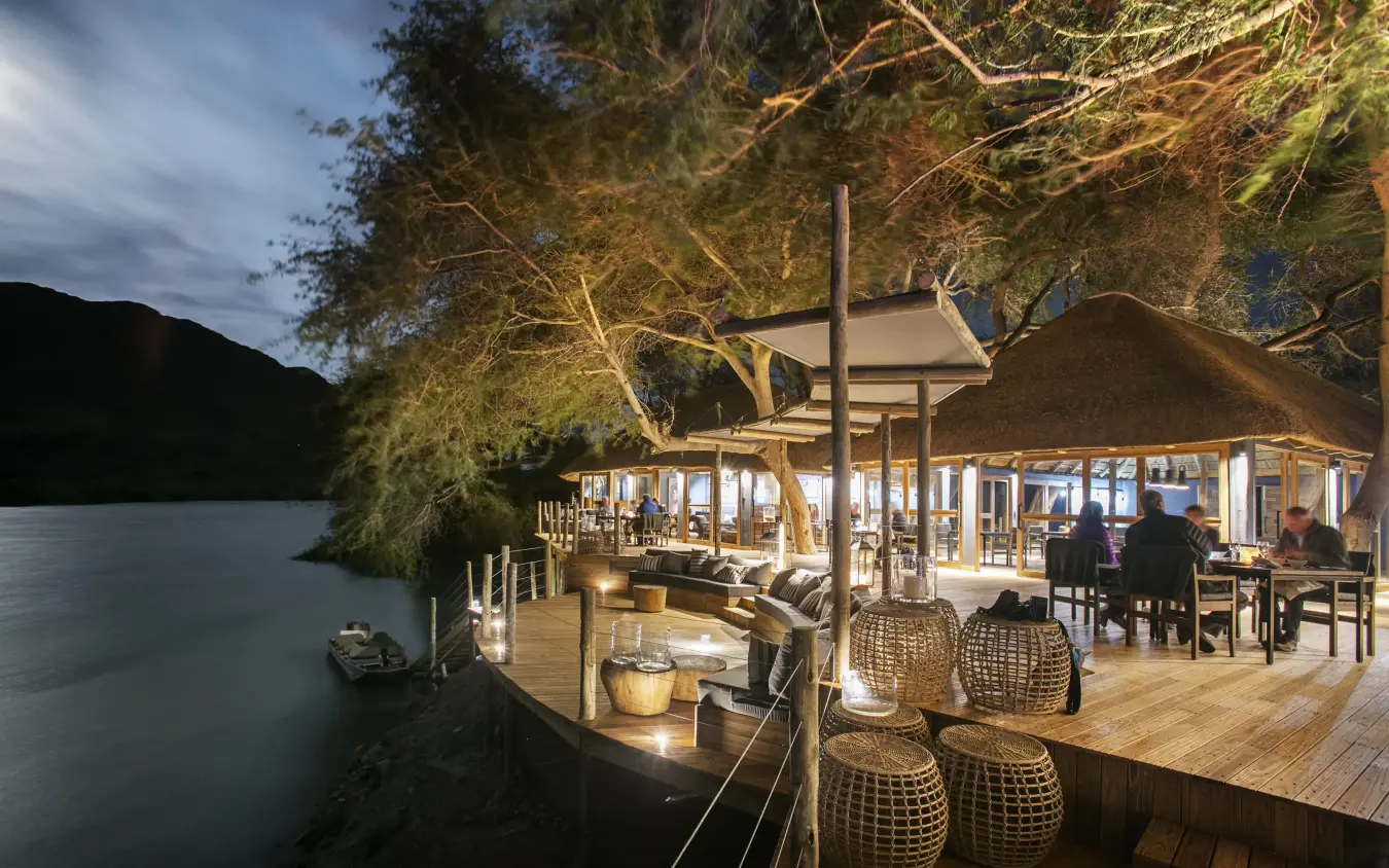 Riverside deck and lounge area at dusk with water view, Serra Cafema, Kunene River, Namibia