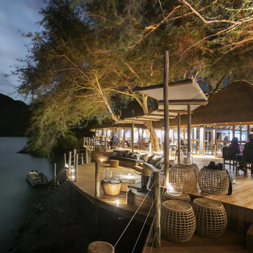 Riverside deck and lounge area at dusk with water view, Serra Cafema, Kunene River, Namibia