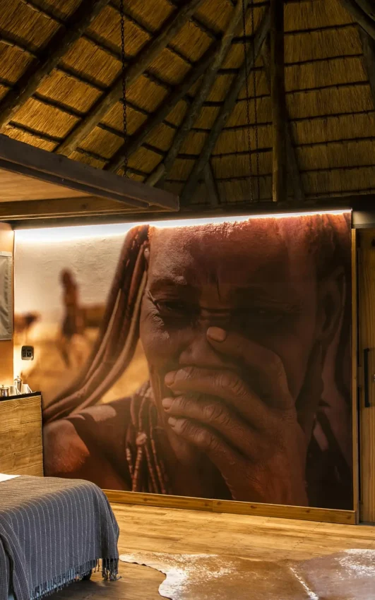 Bedroom interior with large portrait artwork and water views, Serra Cafema, Kunene River, Namibia