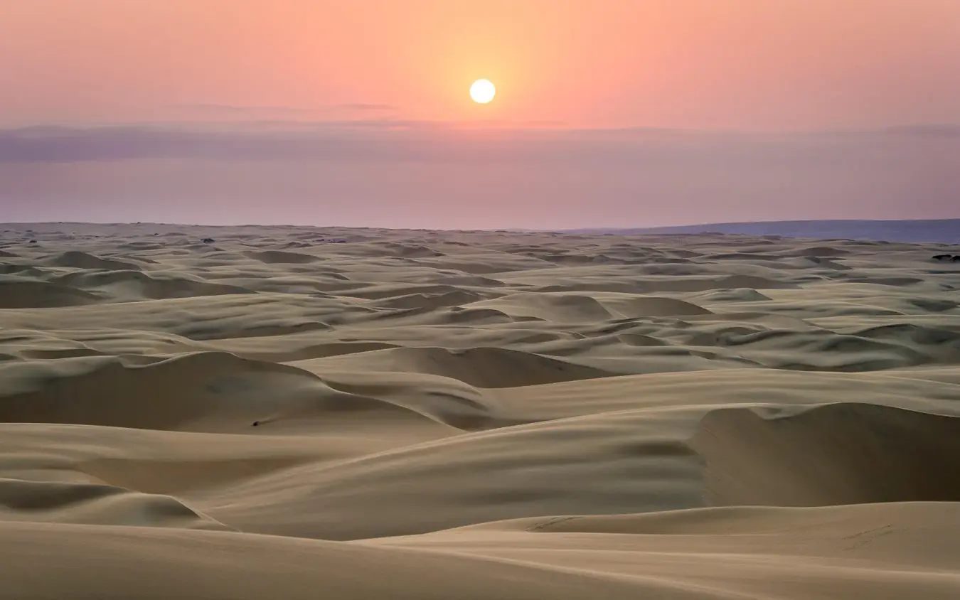 Sand dunes at sunset with golden light across ridges, Serra Cafema, Kunene River, Namibia