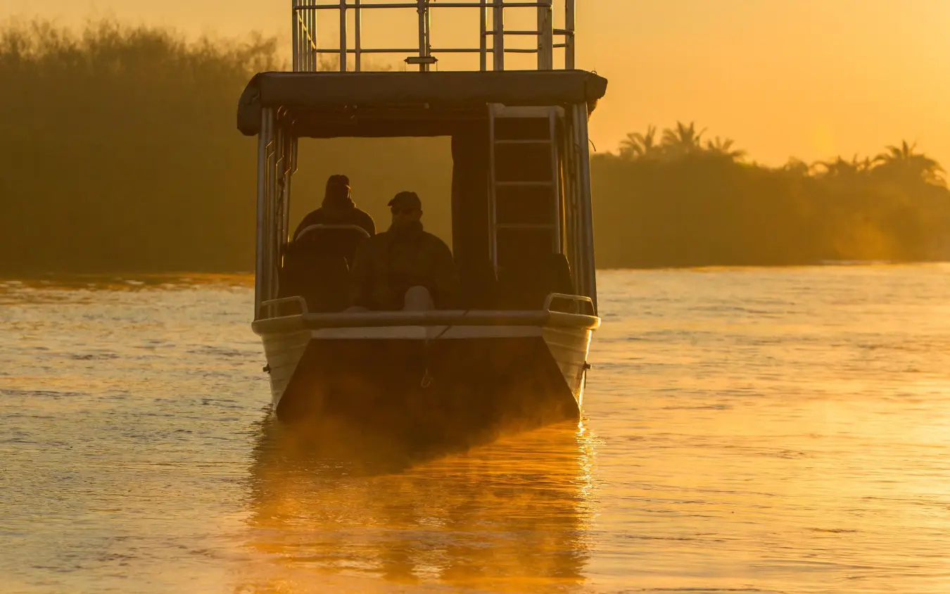 Boat tour at sunrise with silhouetted passengers, Setari, The Okavango Delta, Botswana