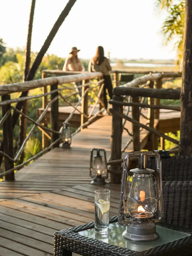 Wooden deck with lanterns overlooking wetland landscape, Setari, The Okavango Delta, Botswana