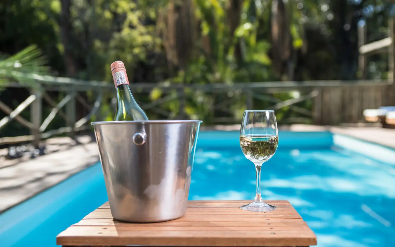 Wine bottle chilling poolside with glass of white wine, Setari, The Okavango Delta, Botswana