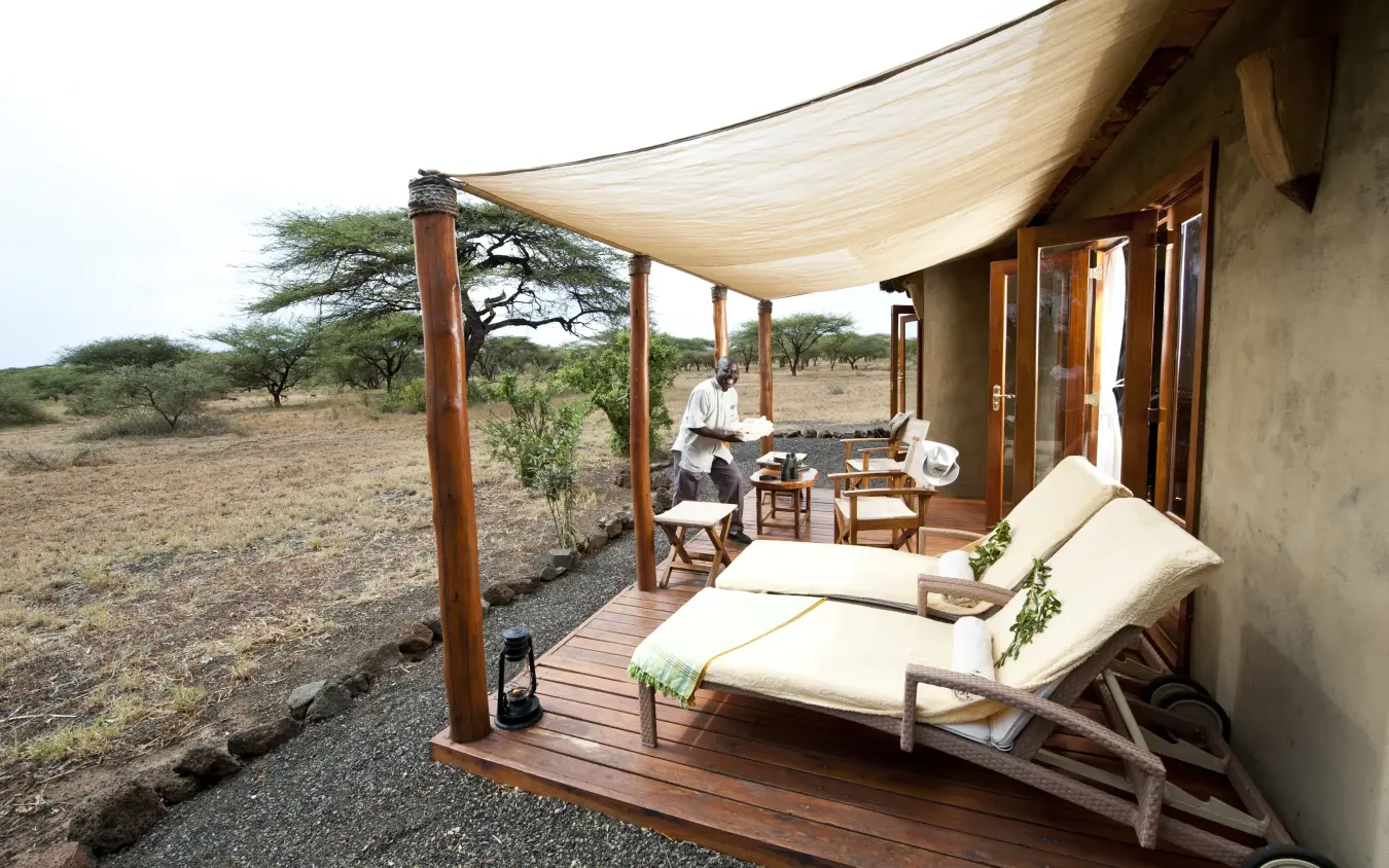 Luxury lodge terrace with loungers and canvas shade overlooking savanna landscape, Severin Safari Camp, Tsavo, Kenya