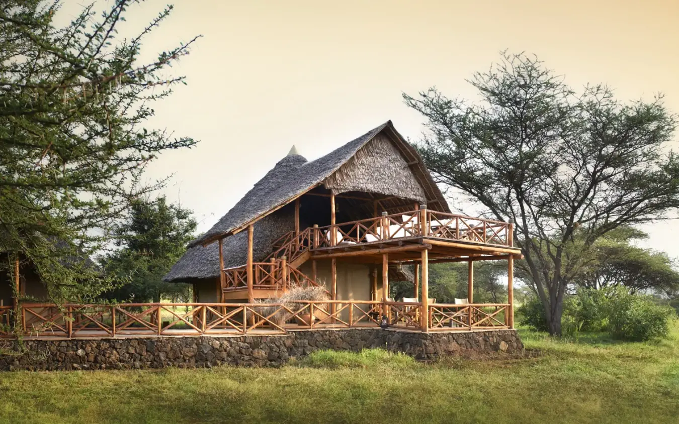 Thatched lodge with wooden deck overlooking savanna grassland, Severin Safari Camp, Tsavo, Kenya