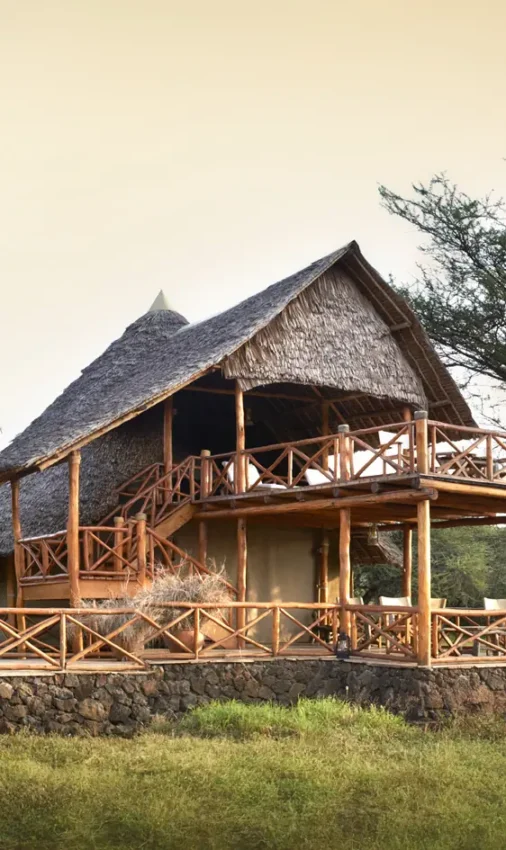 Thatched lodge with wooden deck overlooking savanna grassland, Severin Safari Camp, Tsavo, Kenya