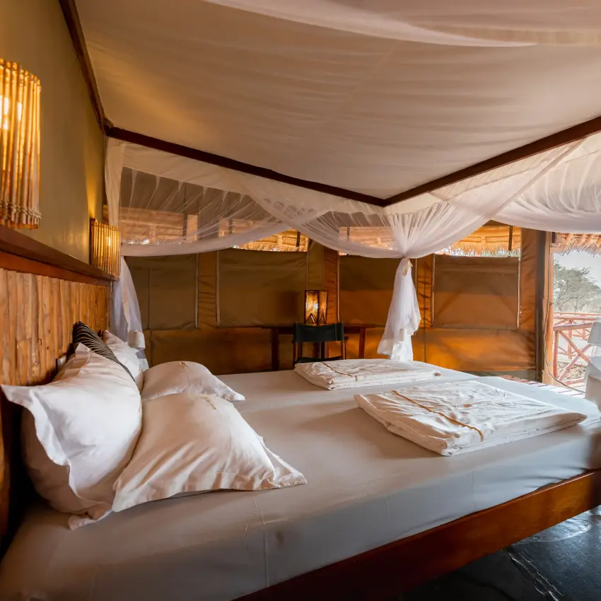 Luxury safari tent interior with canopy bed and open-air viewing platform, Severin Safari Camp, Tsavo, Kenya