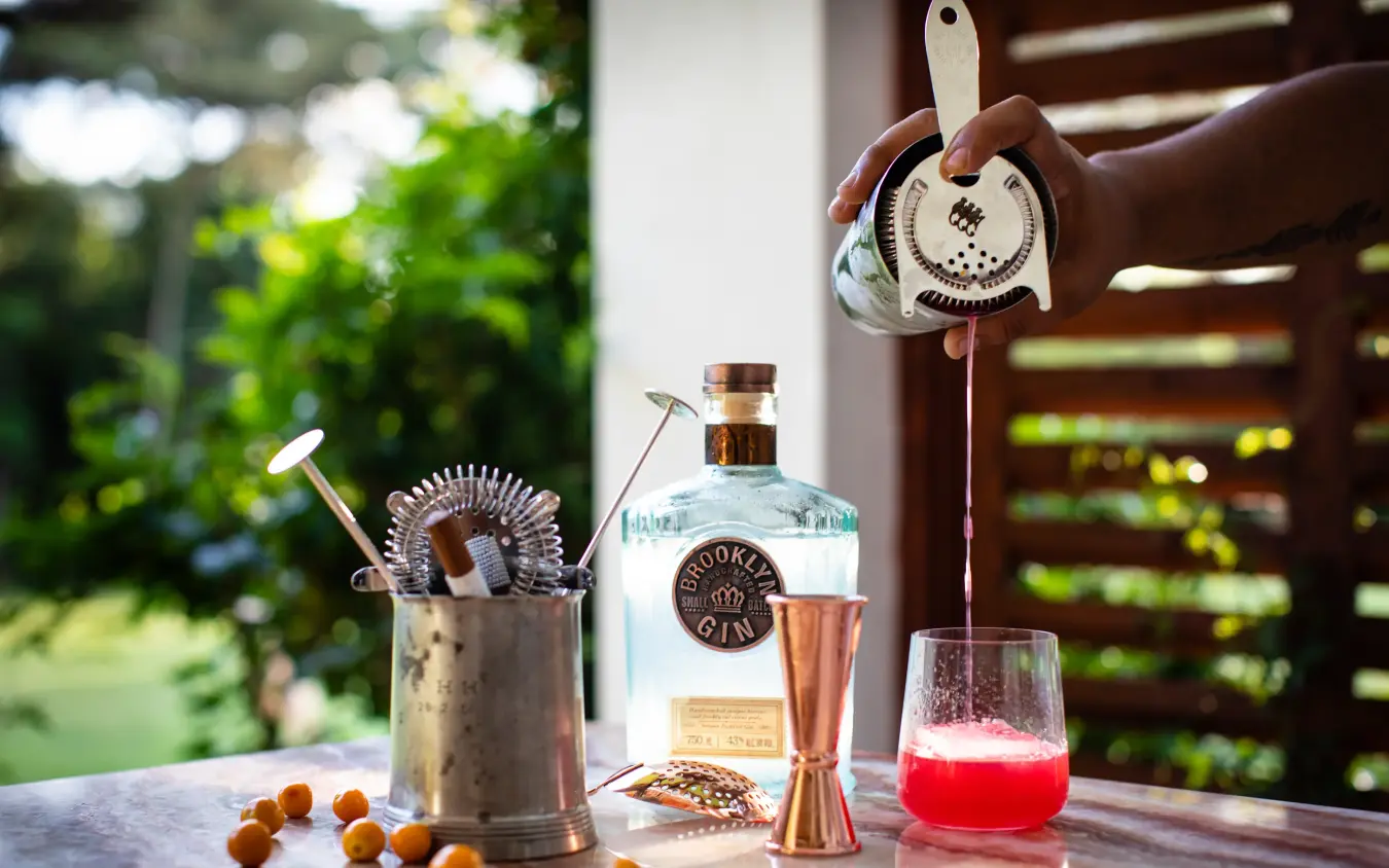 Cocktail preparation setup with gin bottle and bar tools, Sheba’s Secret Garden, Nairobi, Kenya