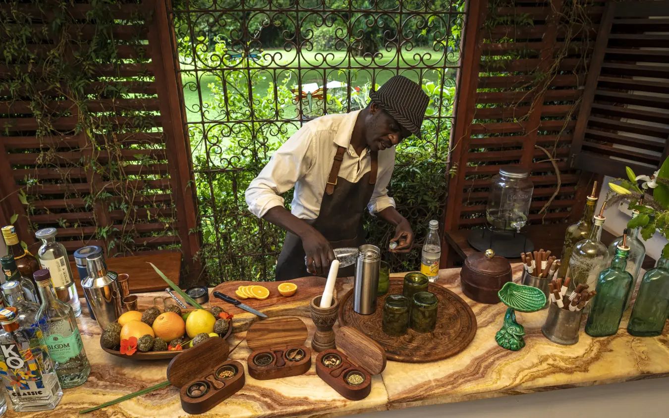 Bartender preparing cocktails at outdoor bar station, Sheba’s Secret Garden, Nairobi, Kenya