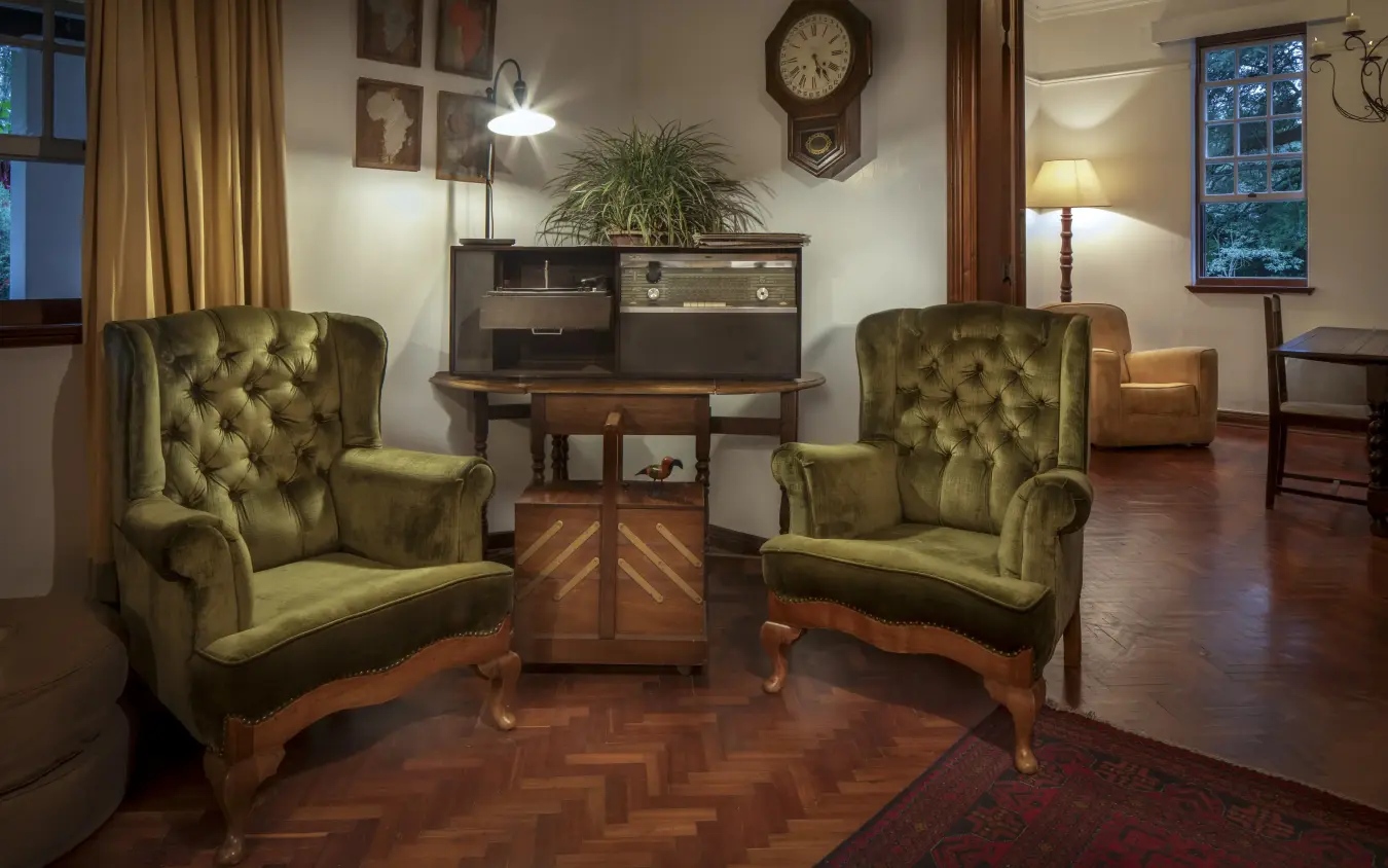 Elegant sitting room with green wingback chairs and wooden furniture, Sheba’s Secret Garden, Nairobi, Kenya