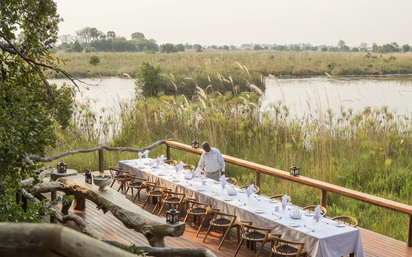 Dining deck overlooking wetland with reeds and water, Shinde, The Okavango Delta, Botswana